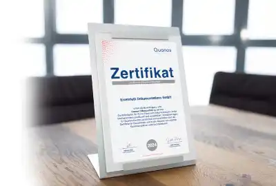 Zertifikat für die Quanos Silber-Partnerschaft der Eisenrieth Dokumentations GmbH auf einem Tisch